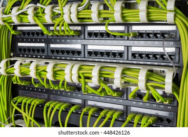 Rows Of Green Network Cables Connected To Router And Switch Hub In Server Room At Internet Data Center