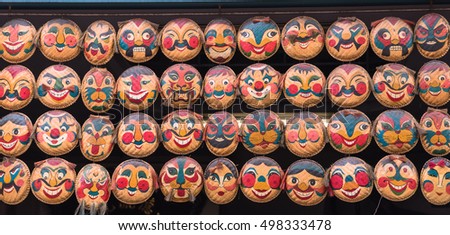 Rows of hanging face painted on woven round bamboo trays. Famous colorful straw tray masks art in Hanoi, Vietnam. Multi-faces souvenir sales in many shops around downtown old quarter. Panorama view