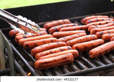 Rows of hot dogs on barbeque grill at park