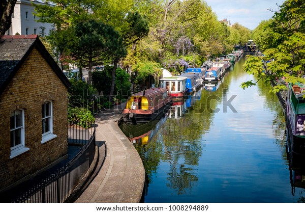 Rows of houseboats and narrow boats on the canal banks\
at Regent\'s Canal next to Paddington in Little Venice, London -\
England, UK