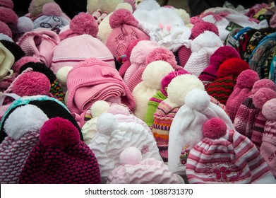 Rows of knitted hats for sale on a market stall in Warsaw, Poland. A colourful collection of bobble hats lined up