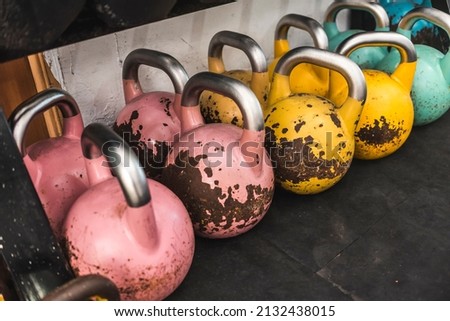 Rows of large color coded kettlebells below. At a hardcore, old school gym.