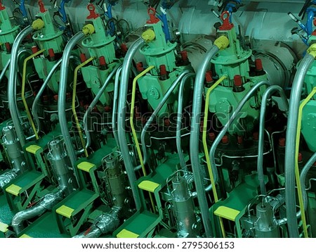 Rows of large marine diesel engine cylinder heads inside a ship engine room operating at Teluk Lamong port area, Gresik, Indonesia. Maritime propulsion technology.