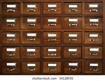 Rows of little drawers with white empty tags in an old furniture module