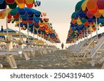 Rows of multi colored beach umbrellas during sunrise in Rimini