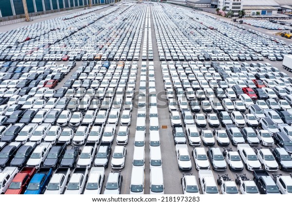 Rows of a new cars automotive line up products\
parked in warehouse of  factory for distribution dealers trading in\
import export, aerial view