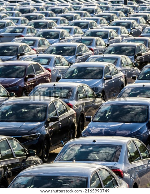 Rows of a new cars parked in a distribution\
center on a car factory\
parking.