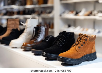 Rows of new leather boots on shelves in shoe store. - Powered by Shutterstock