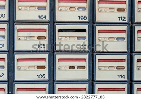 Rows of numbered post office boxes or apartment mailboxes in a wall assembly
