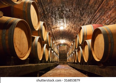 Rows of oak barrels in underground wine cellar