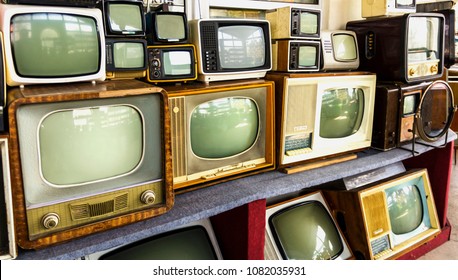Rows of old TVs. The first televisions are tube-type 