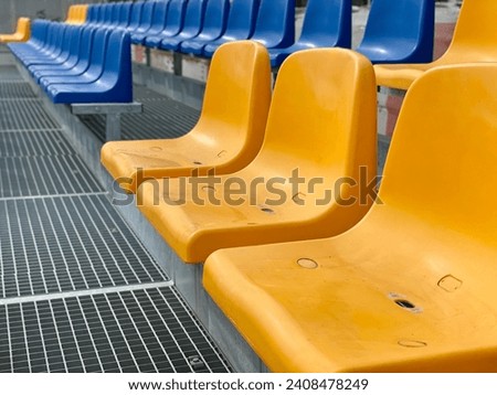 Rows of plastic seats at a stadium. empty coloured plastic seats row at sport stadium. stadium seats background. Empty Rows of Plastic Seats at Stadium