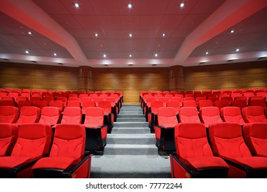 Rows of red arm-chairs are in  empty hall - Shutterstock ID 77772244
