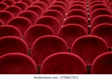 Rows of red seating fill the space in a theater, waiting for an audience before a performance in the evening.