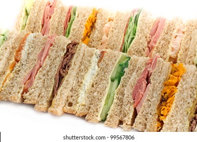 Rows of sandwiches made with sliced bread and cut into triangles