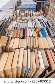 Rows of second hand books displayed for sale outside a street bookstore, affordable reading, literature, education, sustainable consumption and local culture concept