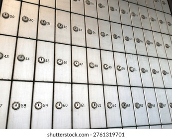 Rows of secure numbered mailboxes in post office setting for public use.