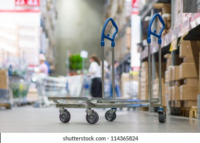 Rows of shelves with boxes and storage carts in modern warehouse