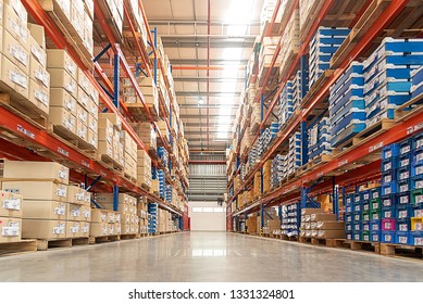 Rows of shelves with goods boxes in huge distribution warehouse at industrial storage factory.