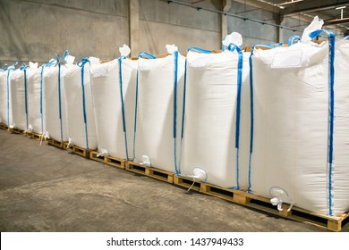 Rows or stacks of white sack bags at large warehouse in modern factory. Packaging in factory or warehouse