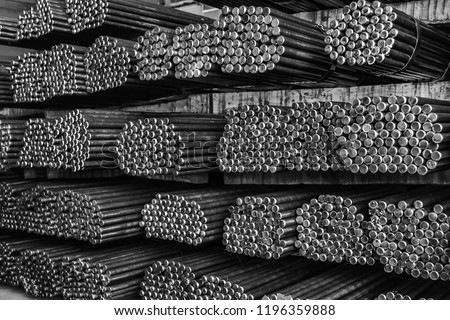 Rows of Steel Round Bar storage and stacking in the warehouse for industrial construction. Black and white with Shallow focus.