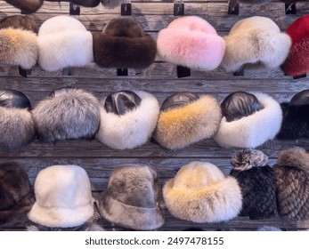 Rows of stylish women's hats of faux fur and leather, with two woven caps (bottom right), on display in an urban clothing shop in southeastern Alaska - Powered by Shutterstock