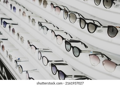 Rows of sunglasses on the counter of an optical store - Shutterstock ID 2161937027