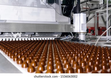 Rows Of Toppings For Chocolates Manufactured By Machine, On A Conveyor Of A Chocolate Factory 