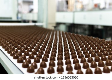 Rows Of Toppings For Chocolates Manufactured By Machine, On A Conveyor Of A Chocolate Factory 