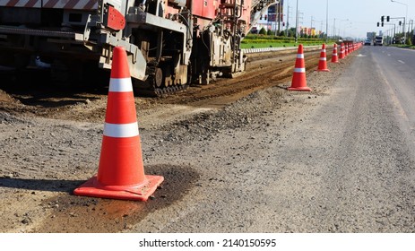 Rows of traffic cones on the road. Red and white plastic cones or temporary traffic control devices for warning to avoid sections of the road under repair. Selective focus on subjects closely