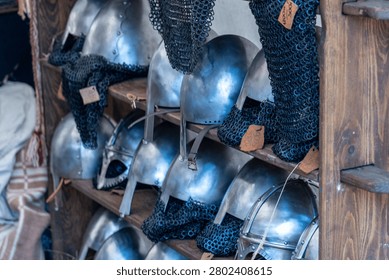 Rows of various ancient warrior helmets and chainmail armor for sale, showing historical equipment
