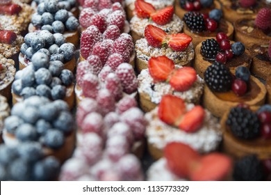 Rows Of Various Fruit Tarts That Are Bite Size