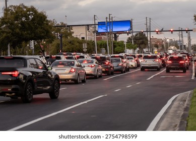 Rows of vehicles stacking through a major urban artery, with red brake lights, lane markings, and crowded commuter traffic extending into the distance