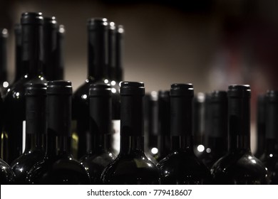 Rows of wine bottles. Dark blurred background,