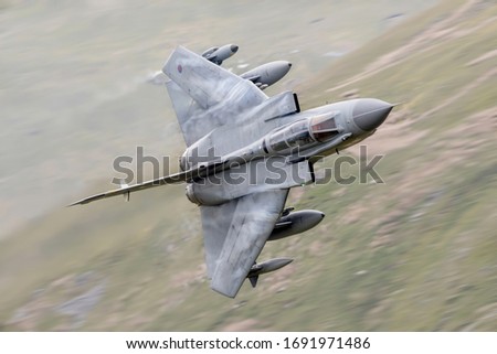 Royal Air Force (RAF) Tornado GR4 strike fighter flying fast  and low level in a mountain valley in Snowdonia North Wales in the Mach Loop