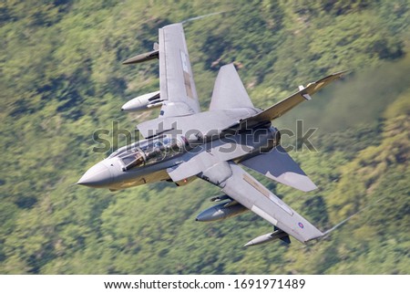 Royal Air Force (RAF) Tornado GR4 strike fighter flying fast  and low level in a mountain valley in Snowdonia North Wales. 