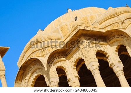 The royal cenotaphs, also called Jaisalmer Chhatris, made of yellow sandstone, stand at sunset in Bada Bagh, Jaisalmer, Rajasthan, India