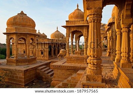 The royal cenotaphs of historic rulers, also known as Jaisalmer Chhatris, made of yellow sandstone at sunset. Bada Bagh in Jaisalmer, Rajasthan, India
