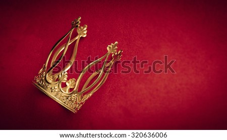 Royal gold crown on red velvet with copy space. Concept of wealth, success and kingdom.