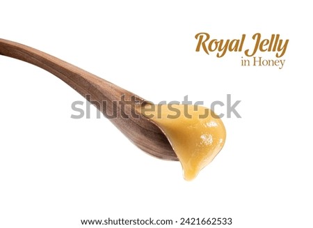 Royal jelly in honey in wooden spoon