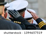 Royal Navy officers salute during Remembrance Day commemorations.