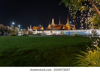 The Royal Palace of Thailand photographed from Sanam Luang at night, with the golden pagoda and chapel of Wat Phra Kaew illuminated by lighting on October 15, 2024. - Powered by Shutterstock