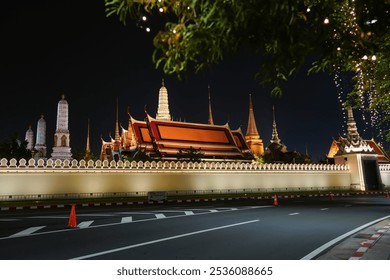 The Royal Palace of Thailand photographed from Sanam Luang at night, with the golden pagoda and chapel of Wat Phra Kaew illuminated by lighting on October 15, 2024. - Powered by Shutterstock