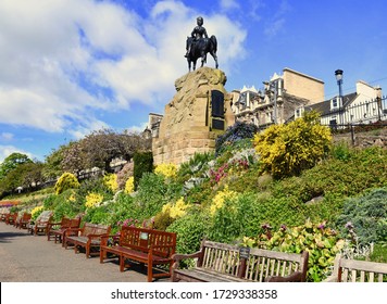 Royal Scotts Bronze horse statue and Royal Scotts trooper dressed in uniform at the entrance to Princes street gardens. Spring flower display and empty park benches. Edinburgh, SCOTLAND . May 2020