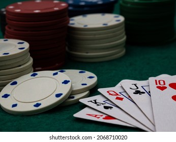 Royal Straight Flush Poker Cards With Stack Of Poker Chips On A Green Felt Table Background