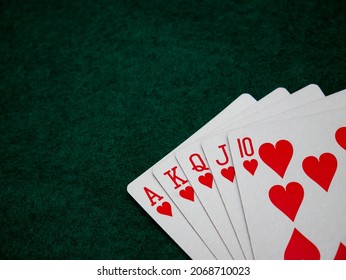 Royal Straight Flush Poker Cards On A Green Felt Table Background