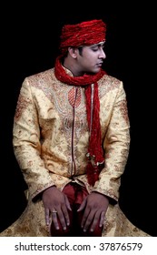 A Royal Young Afghan Man In Prayers, On Black Studio Background.