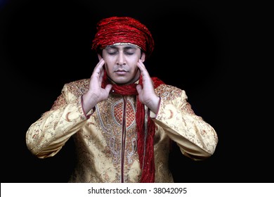 A Royal Young Afghan Man In Prayers, On Black Studio Background.