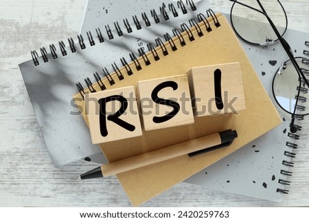 RSI - Acronym made of wooden blocks with letters on a gray notepad, Relative Strength Index. Financial market concept