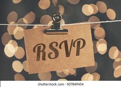 RSVP sign pegged to a string with blurred bokeh lights in the background